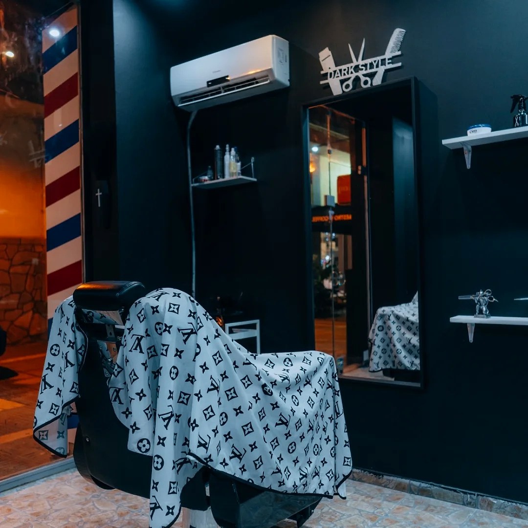 Το εσωτερικό του dark style barber, με τον στύλο του κουρέα και τους μαύρους τοίχους